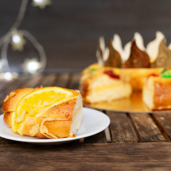 piece of Roscon de Reyes traditional spanish cake for Epiphany festivites on wooden table