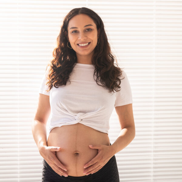 Pregnant woman touching her belly, copy space. Pregnancy and maternity leave.